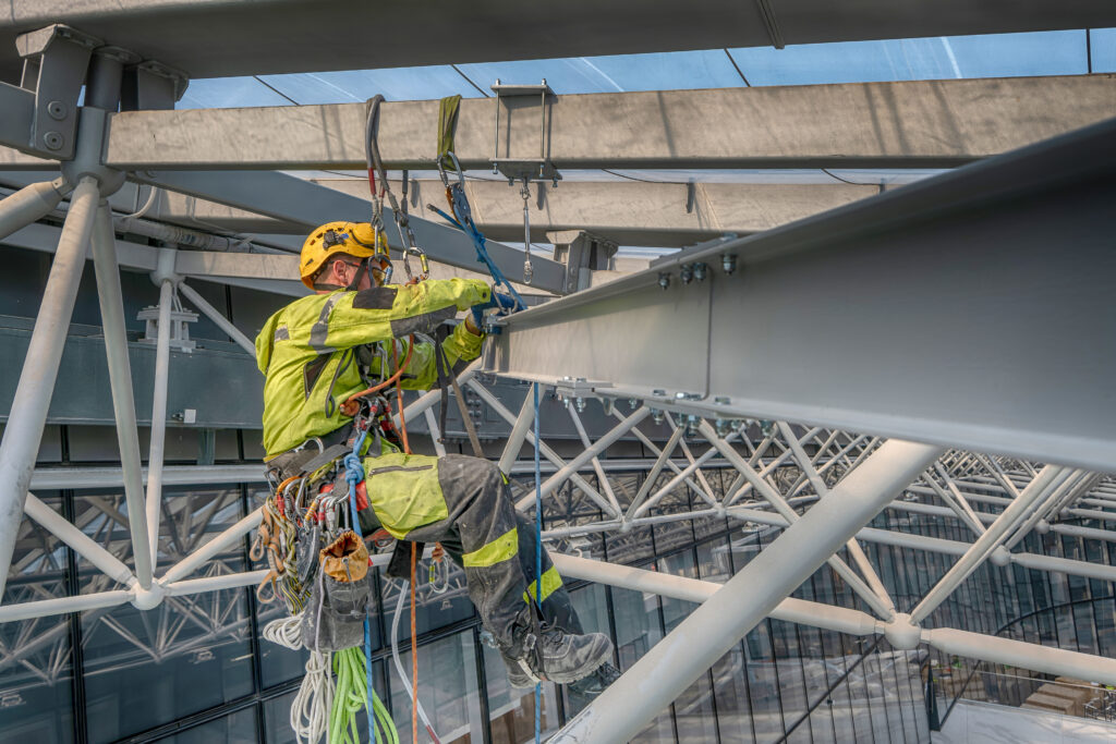 Rope access working installing metal beam