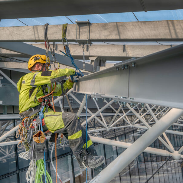 Rope access working installing metal beam